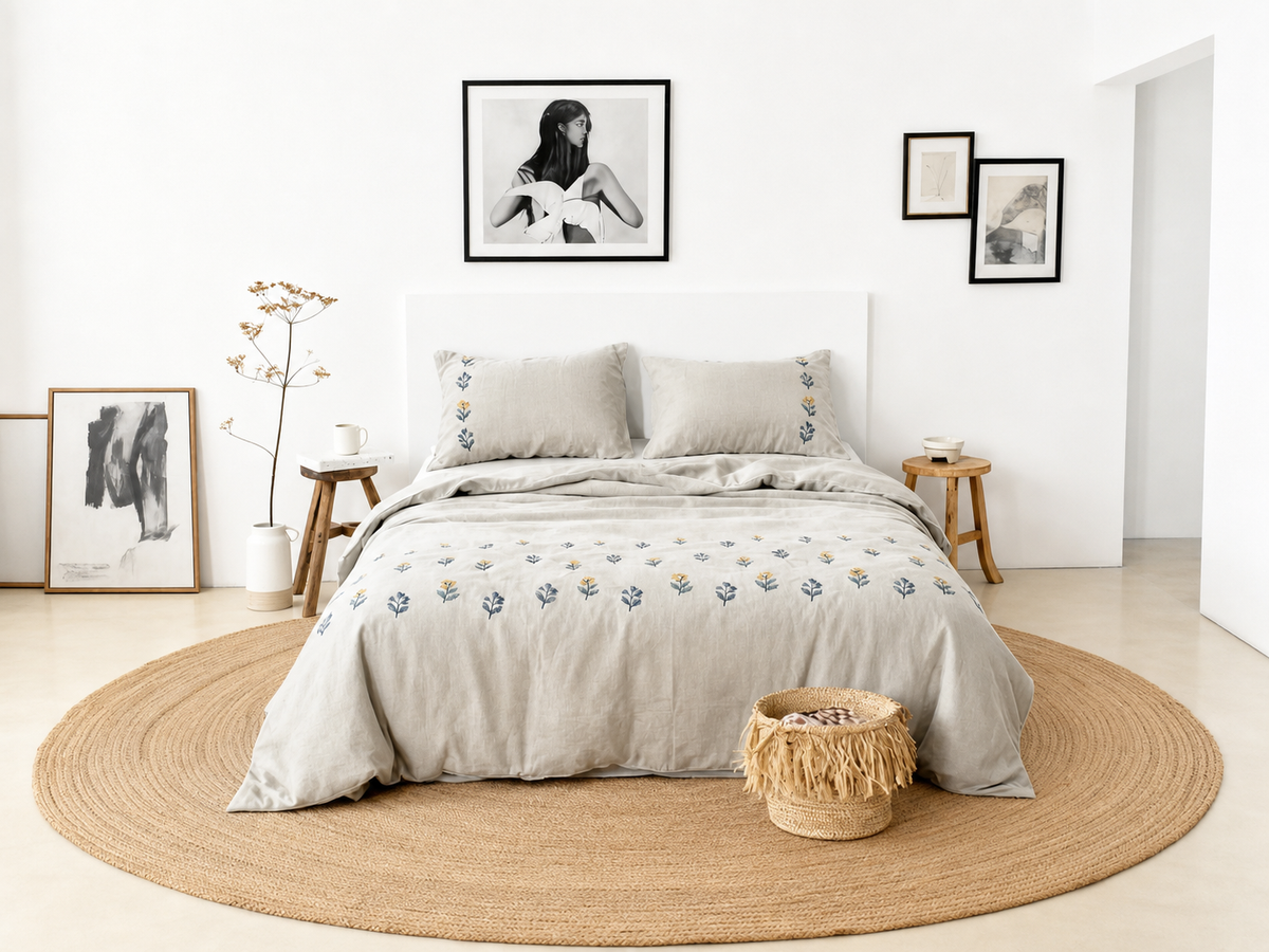 Light neutral duvet cover with small embroidered flowers on a white platform bed