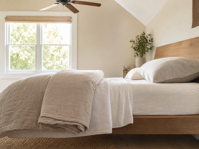 Sheet, light cover, and folded spare blanket arranged as separate warm-weather bed layers