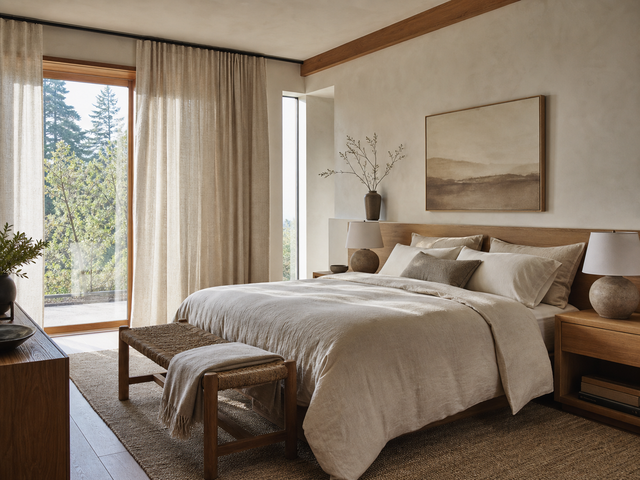 Organic modern bedroom with oatmeal bedding, warm wood, and softly textured curtains