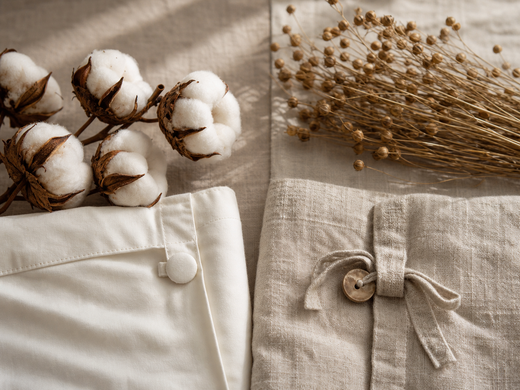 Cotton bolls and smooth duvet-cover fabric beside flax stems and textured linen duvet-cover fabric