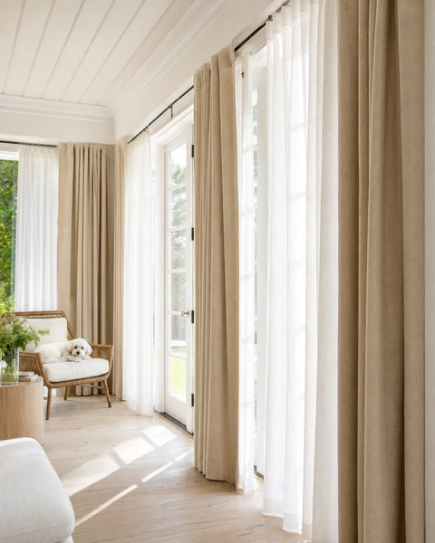 Layered sheer and linen drapery in a relaxed family room